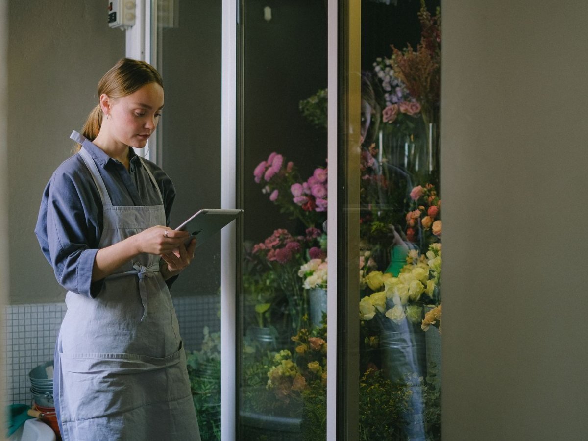 Accessibilité des sites de vente : la DGCCRF contrôle, et la moitié des sites sont en défaut Une fleuriste en tablier utilise une tablette dans sa boutique