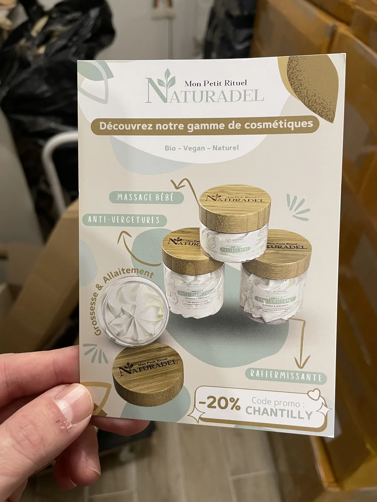 Carte publicitaire d’une gamme de cosmétiques maman-bébé présentant quatre pots