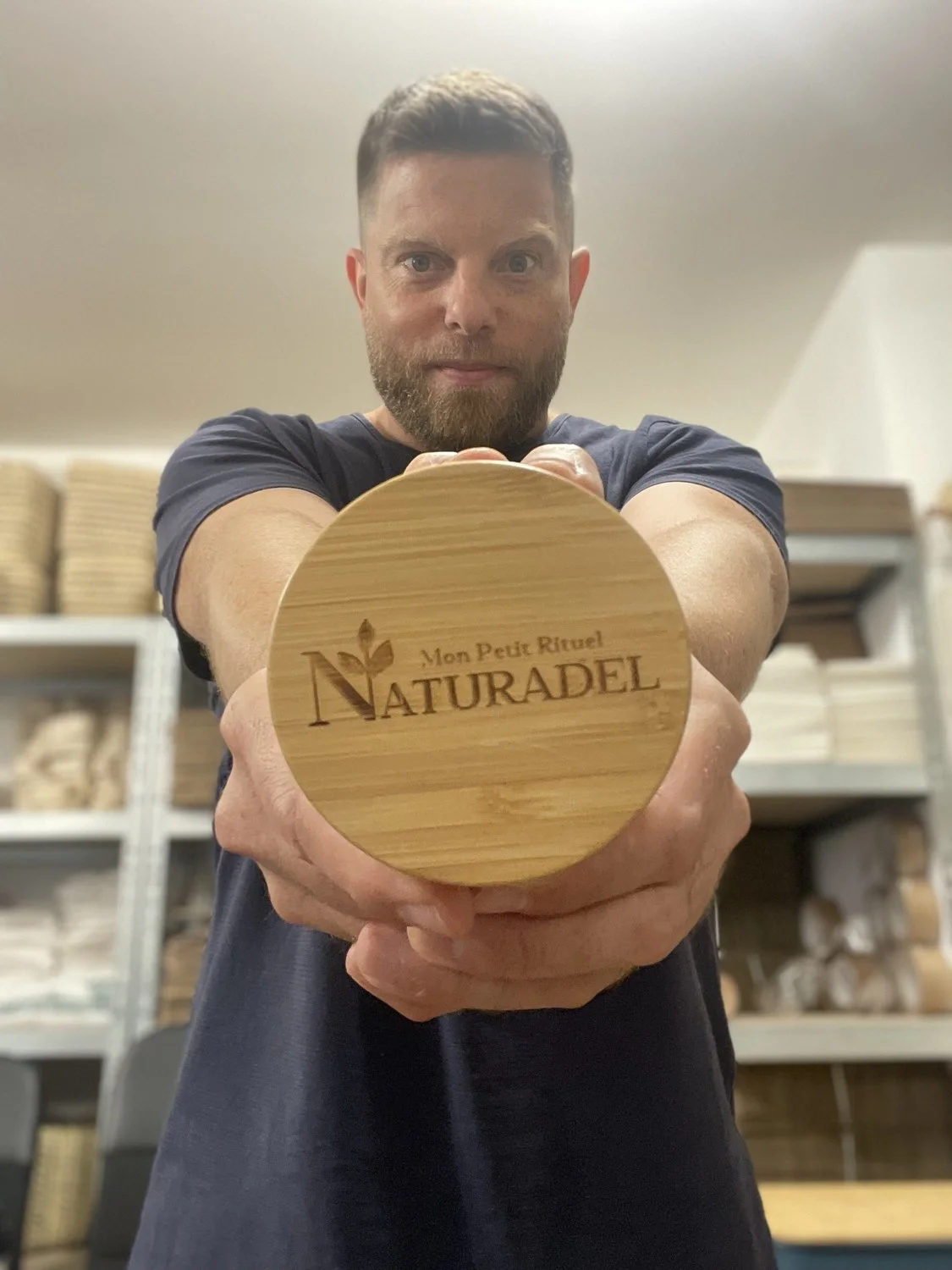 Christophe Millet dans son atelier, tenant un couvercle en bambou gravé