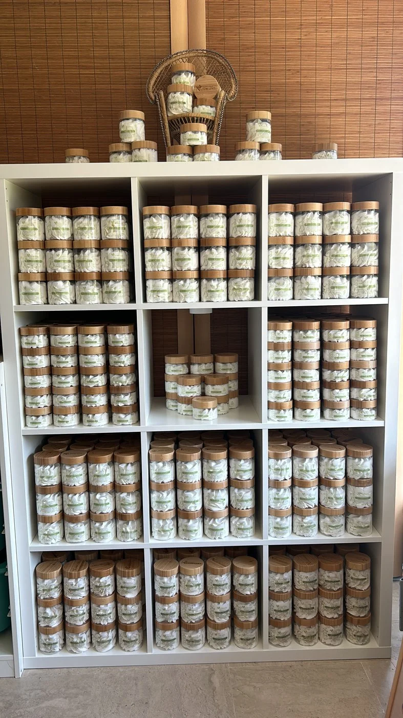 Étagère de stock remplie de pots de cosmétique à couvercle en bambou
