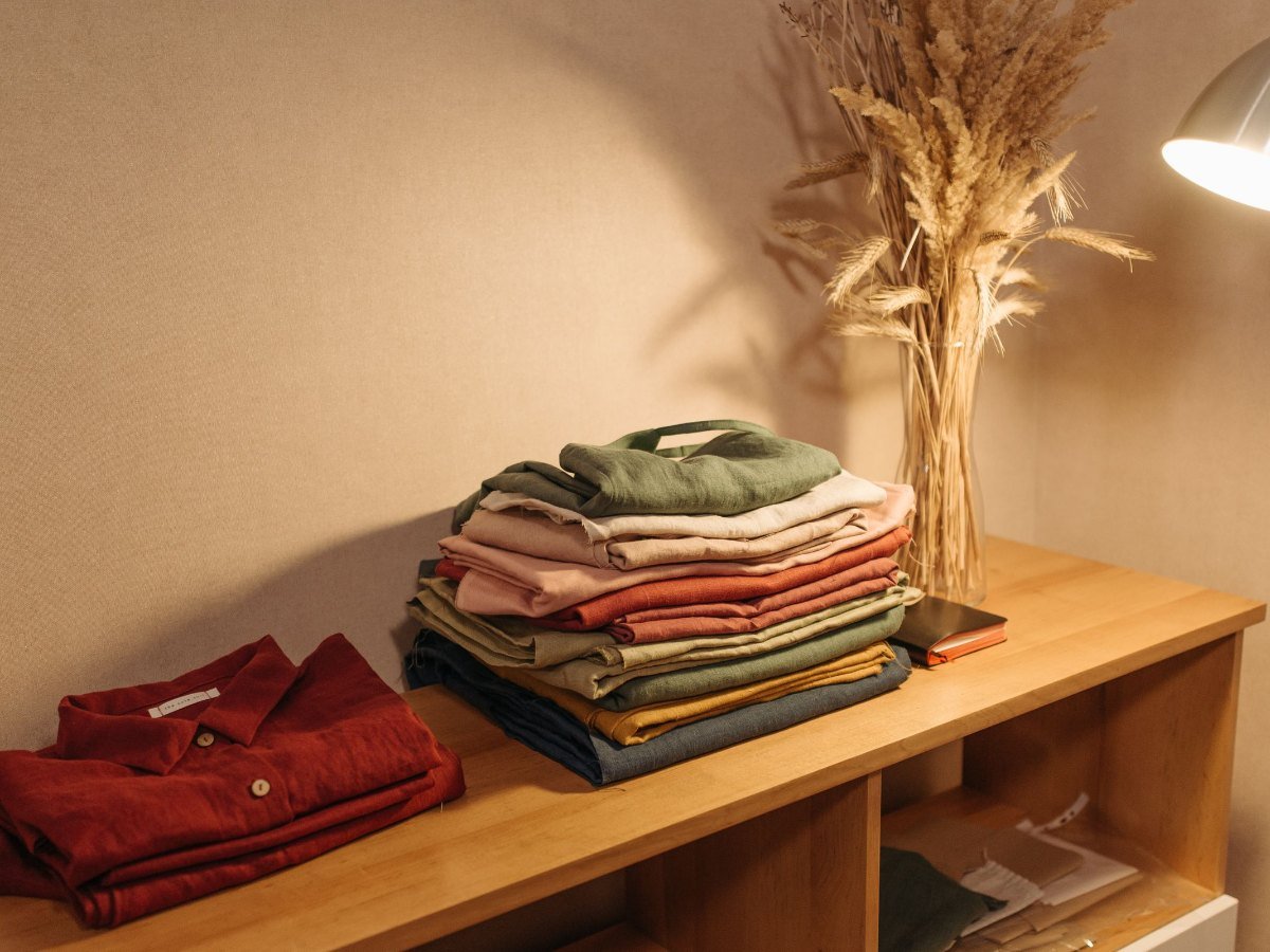 Une pile de vetements en lin plies sur une table en bois