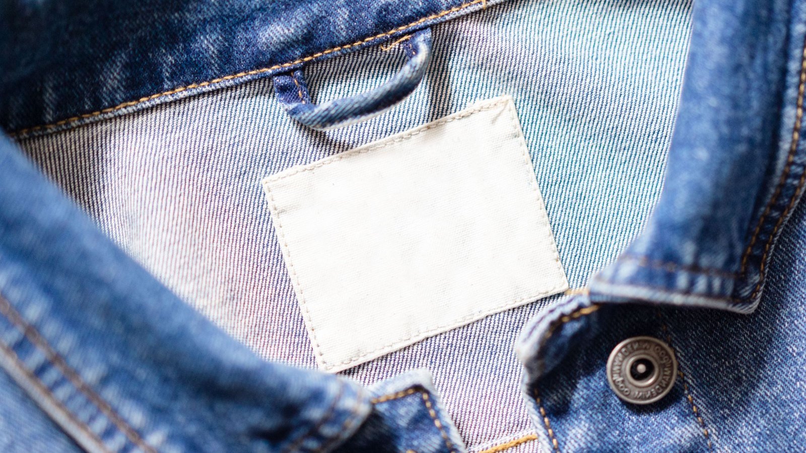 Le col d une veste en jean avec son etiquette blanche