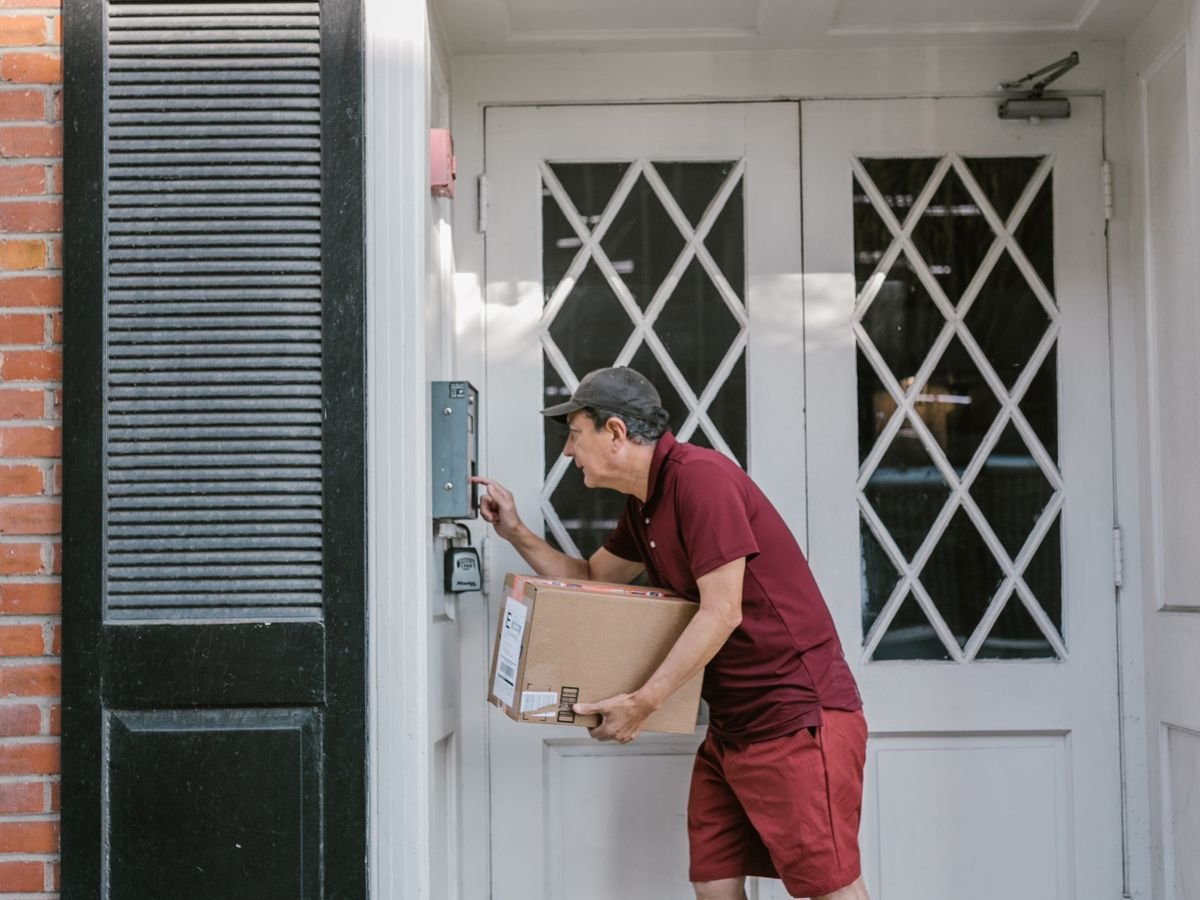 Le dropshipping vu du vendeur : ce dont vous répondez vraiment Livreur remettant un colis devant la porte d’un logement