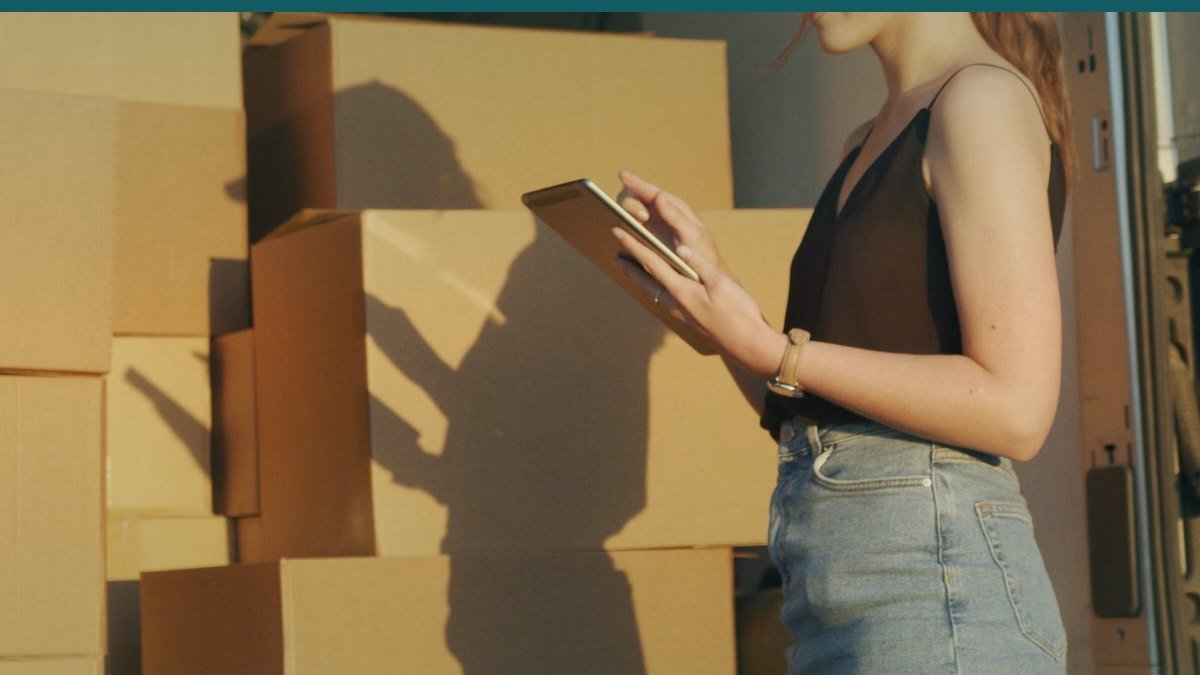 Une personne manipule des cartons dans un local de stockage