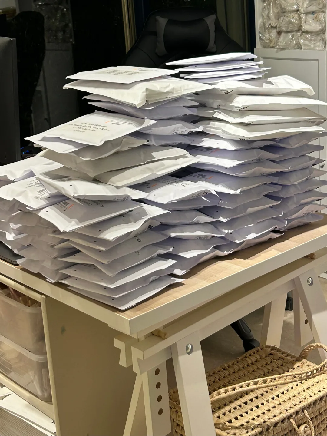 Pile d’enveloppes matelassées prêtes à l’expédition sur un établi du second atelier