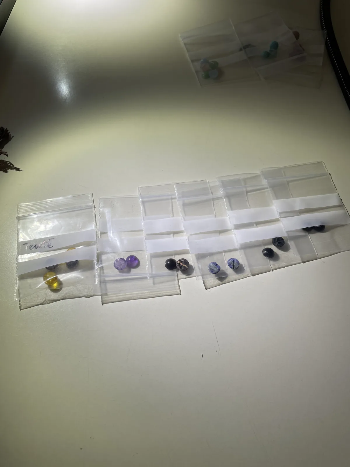 Échantillons de perles en pierres naturelles ensachés par lot de deux avant analyse en laboratoire de gemmologie