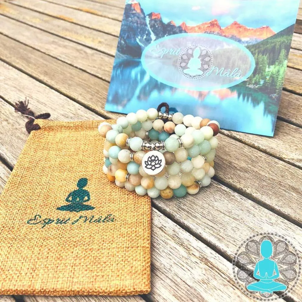 Mâlâ en amazonite posé près d’une pochette en jute imprimée au logo de la marque