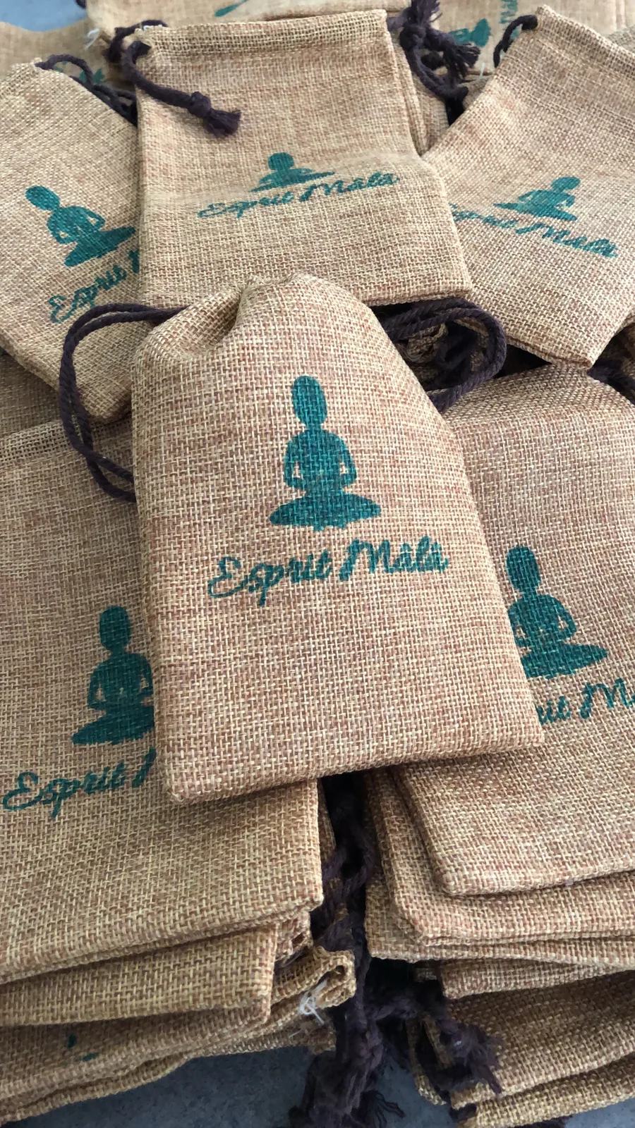Pile de pochettes en jute sérigraphiées au logo d’une marque de bijoux