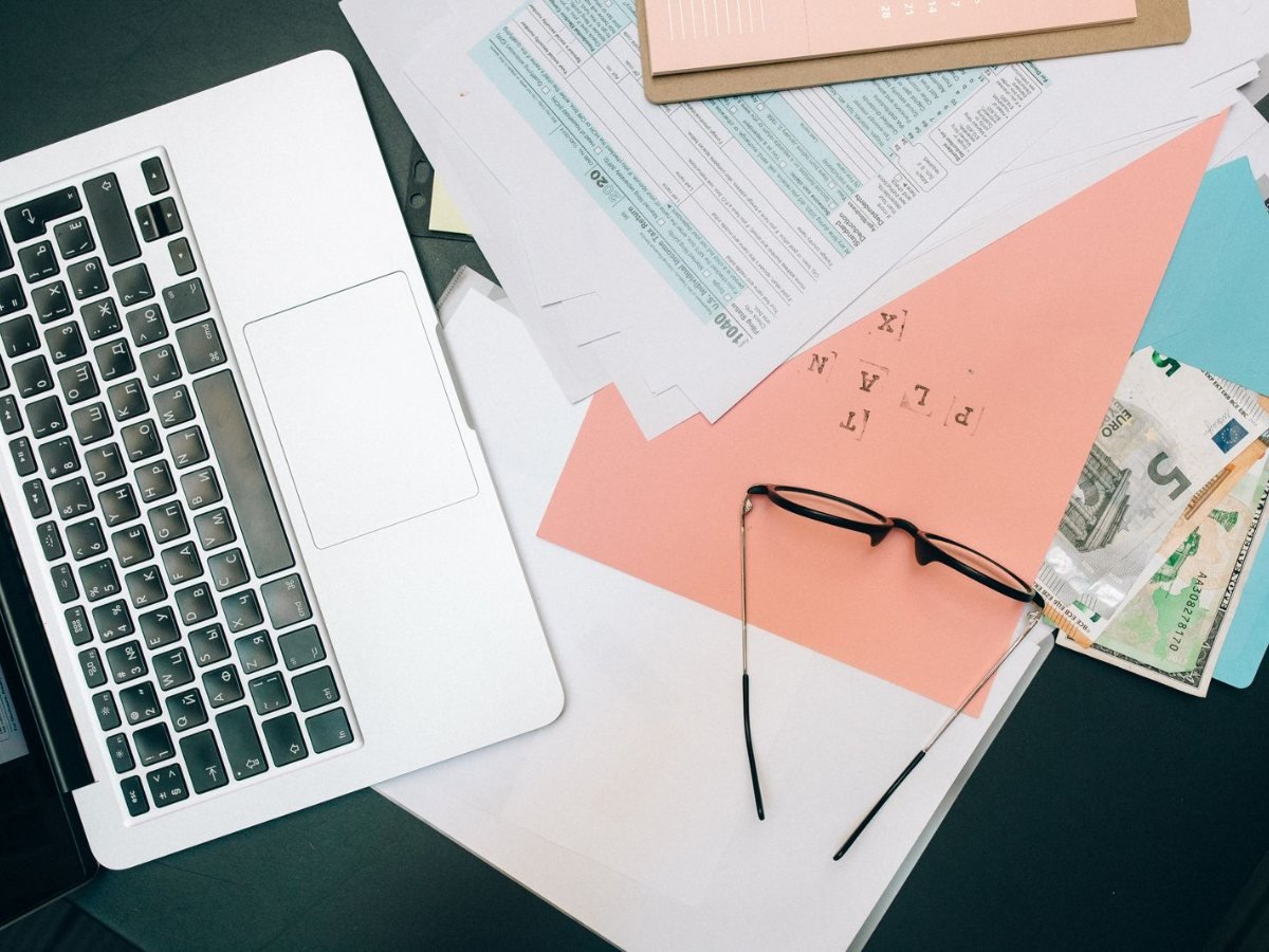 Un bureau range avec un ordinateur portable, des documents et des lunettes