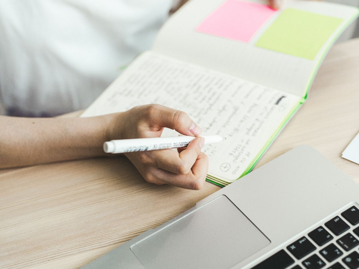 Une femme écrit des notes à son bureau