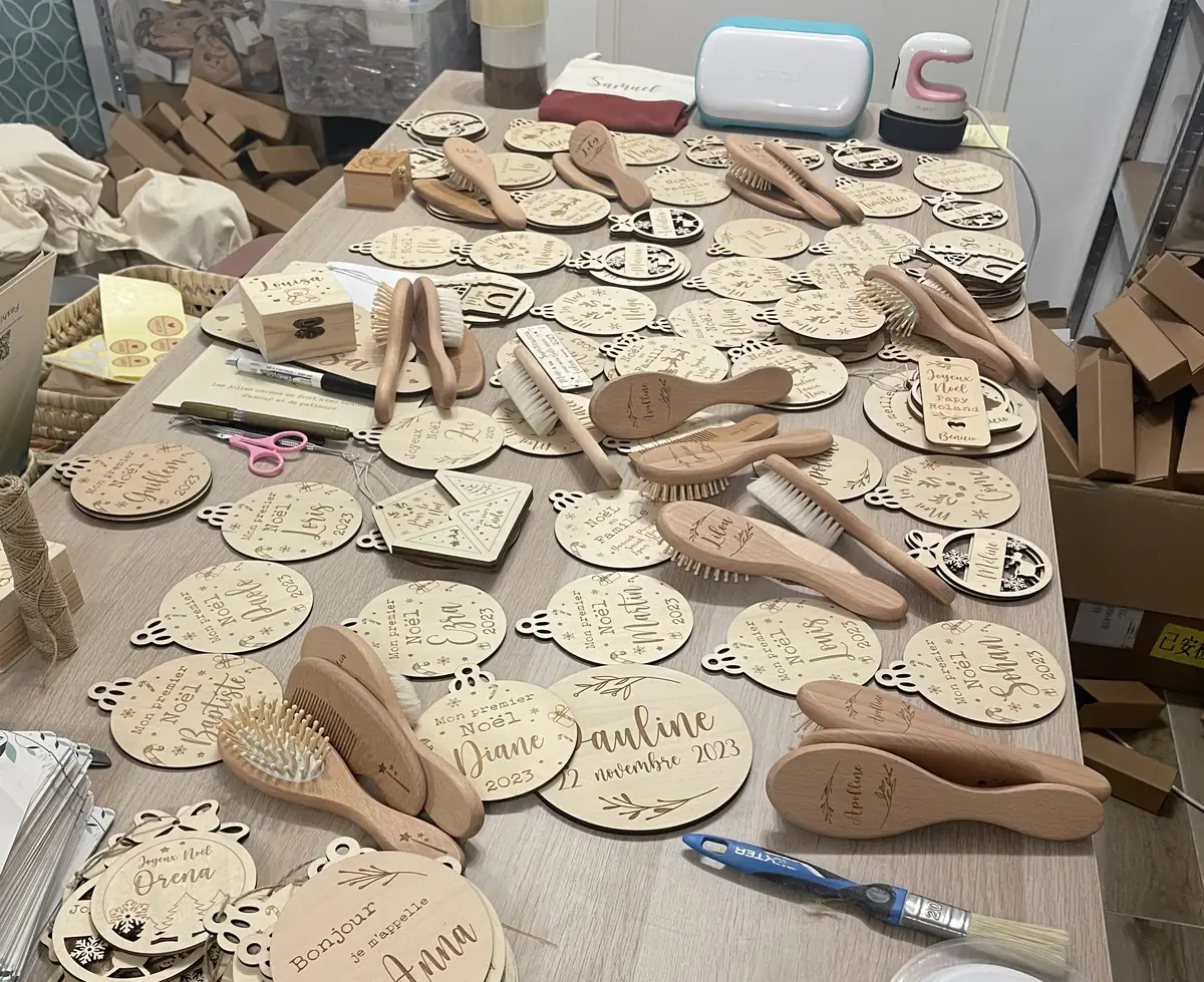 Commandes de Noël personnalisées en attente de conditionnement sur une table d’atelier