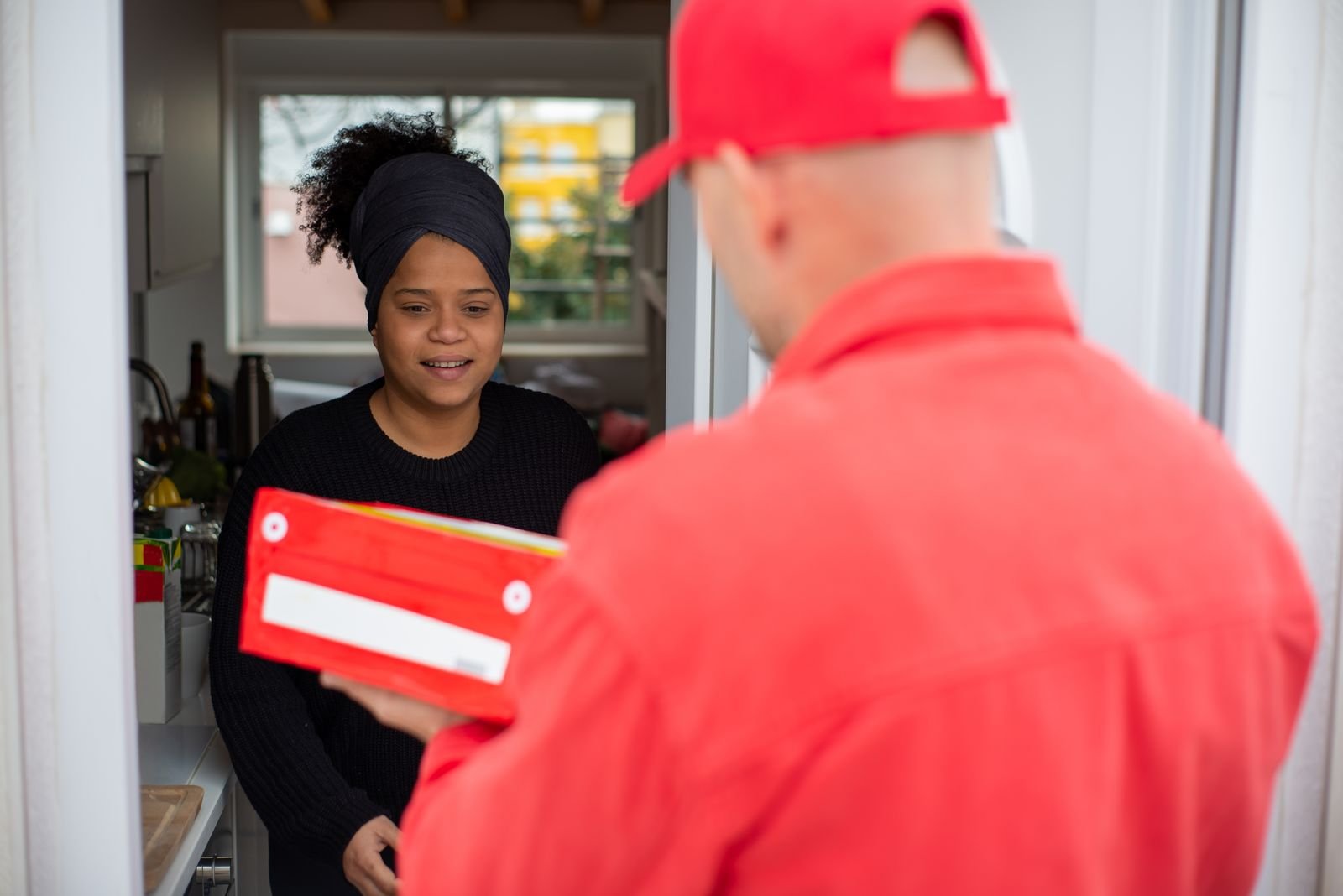 Une cliente reçoit son colis à la porte