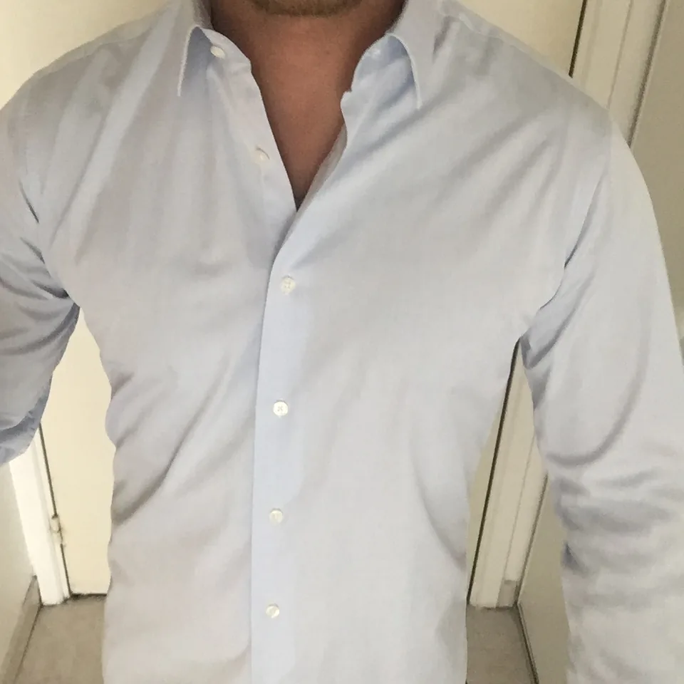 Chemise bleu ciel portée, col ouvert vu de près