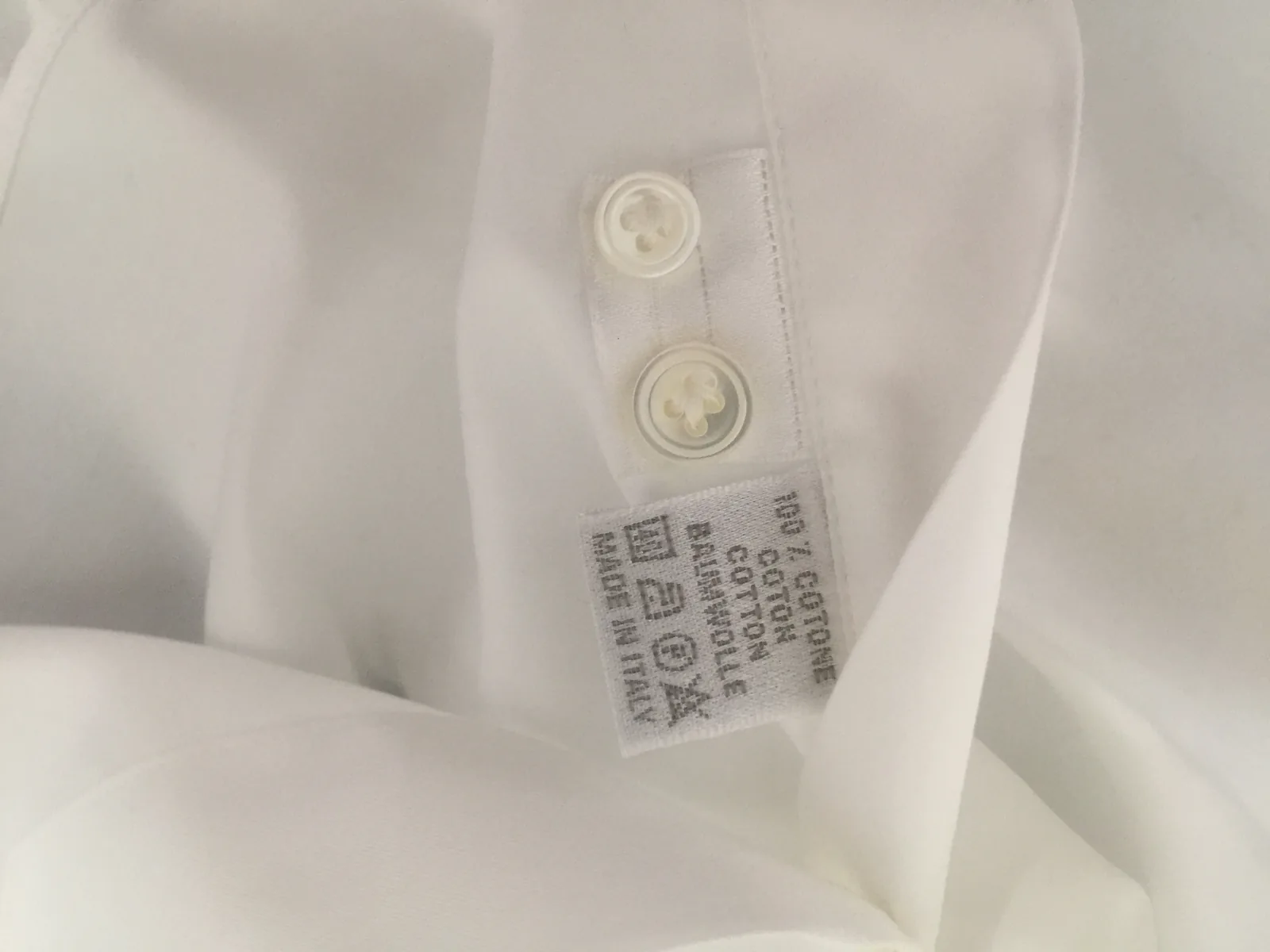 Étiquette de composition 100 % coton, fabriquée en Italie, cousue au poignet