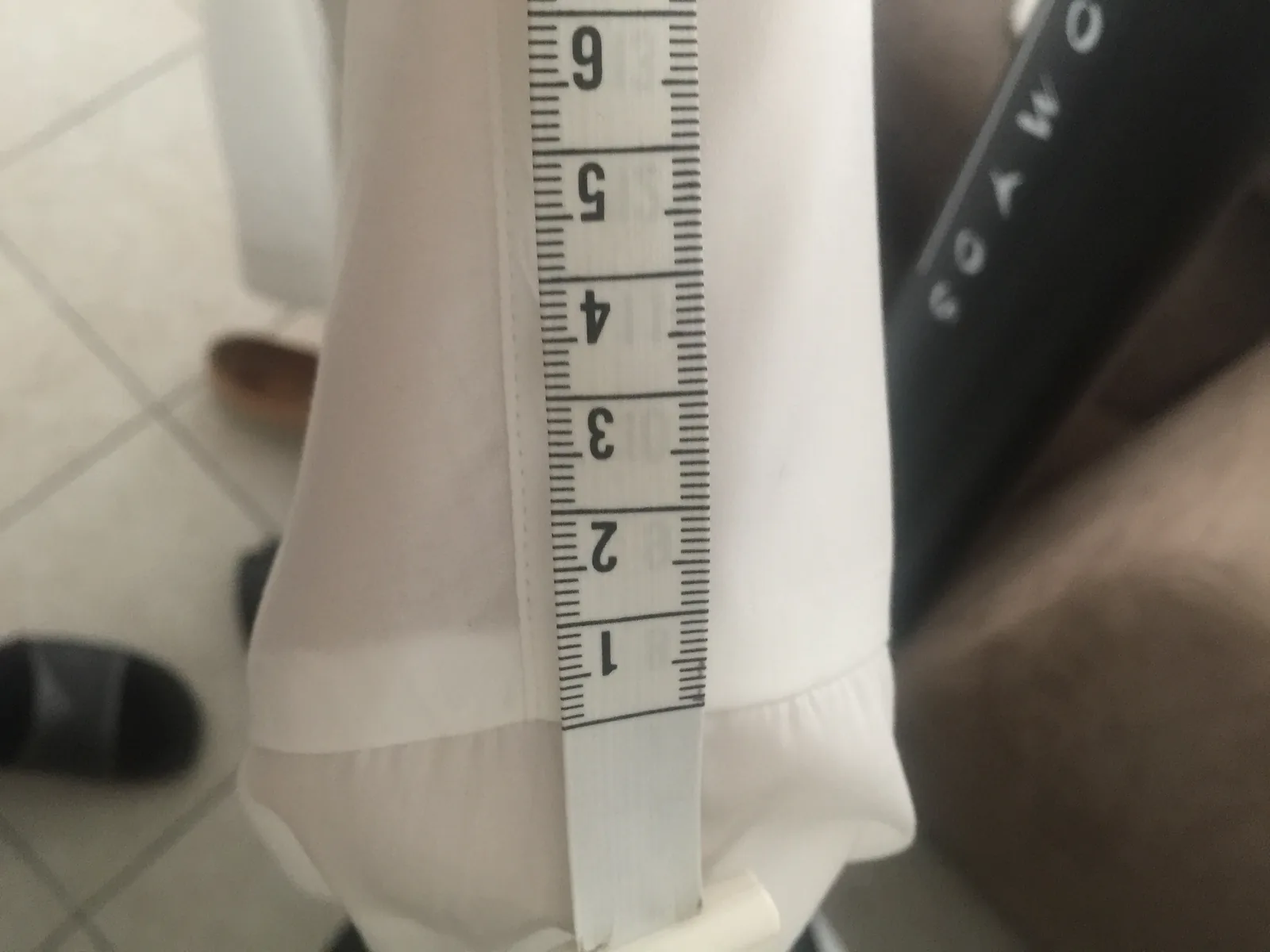 Largeur de poignet mesurée au mètre ruban sur une chemise blanche
