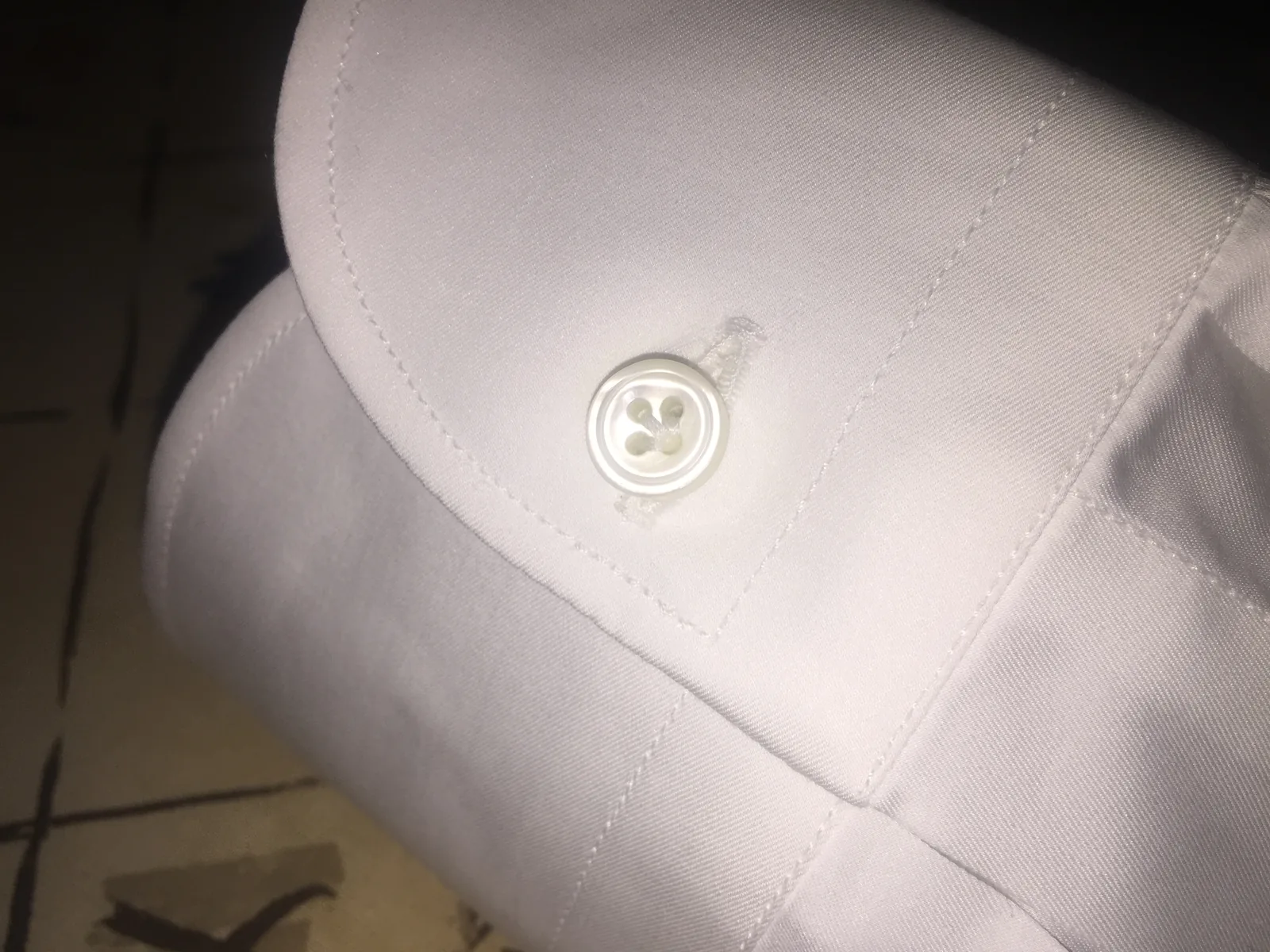 Poignet de chemise blanche avec bouton en nacre à quatre trous