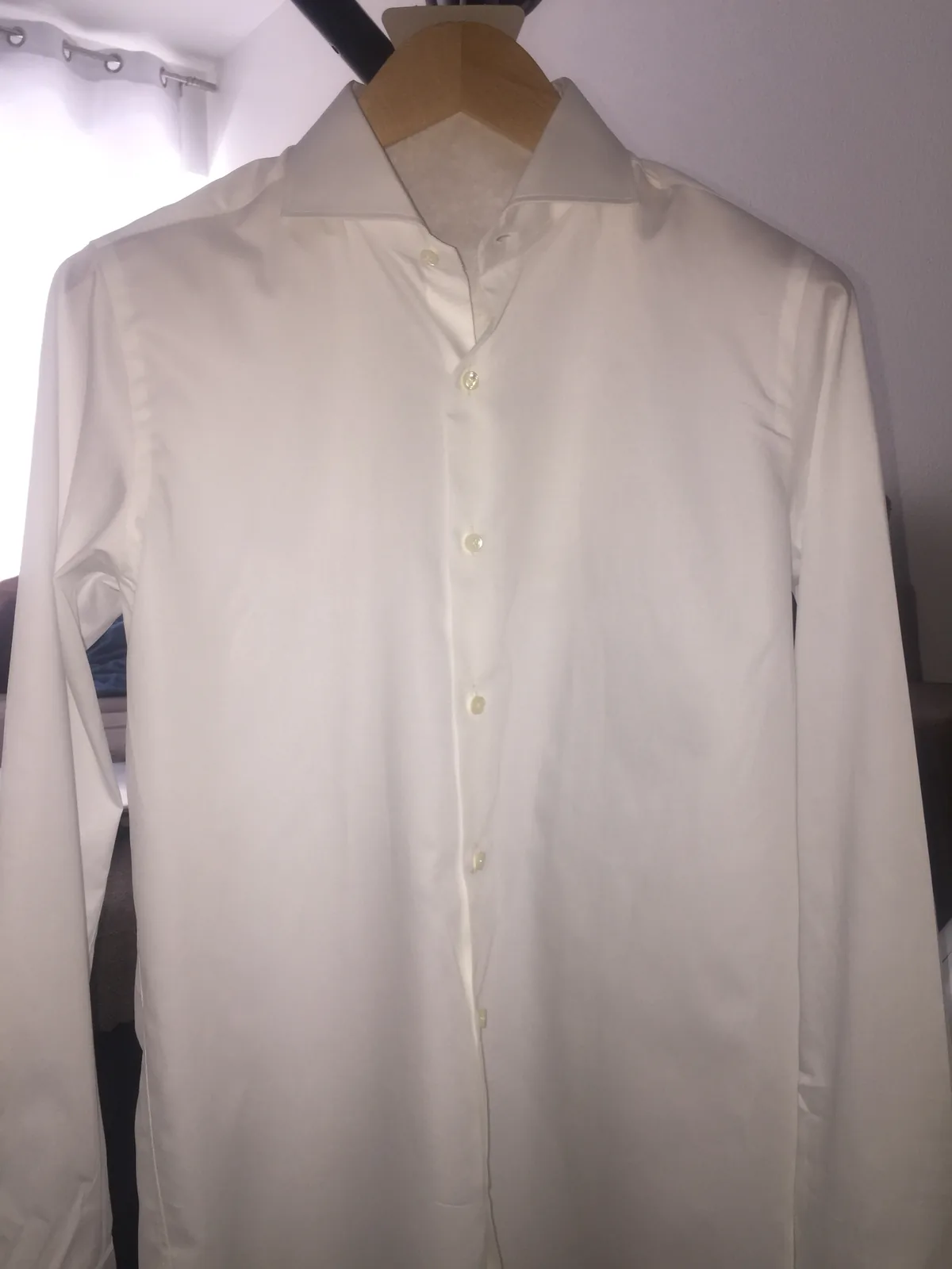 Prototype de chemise blanche en coton italien suspendu à un cintre