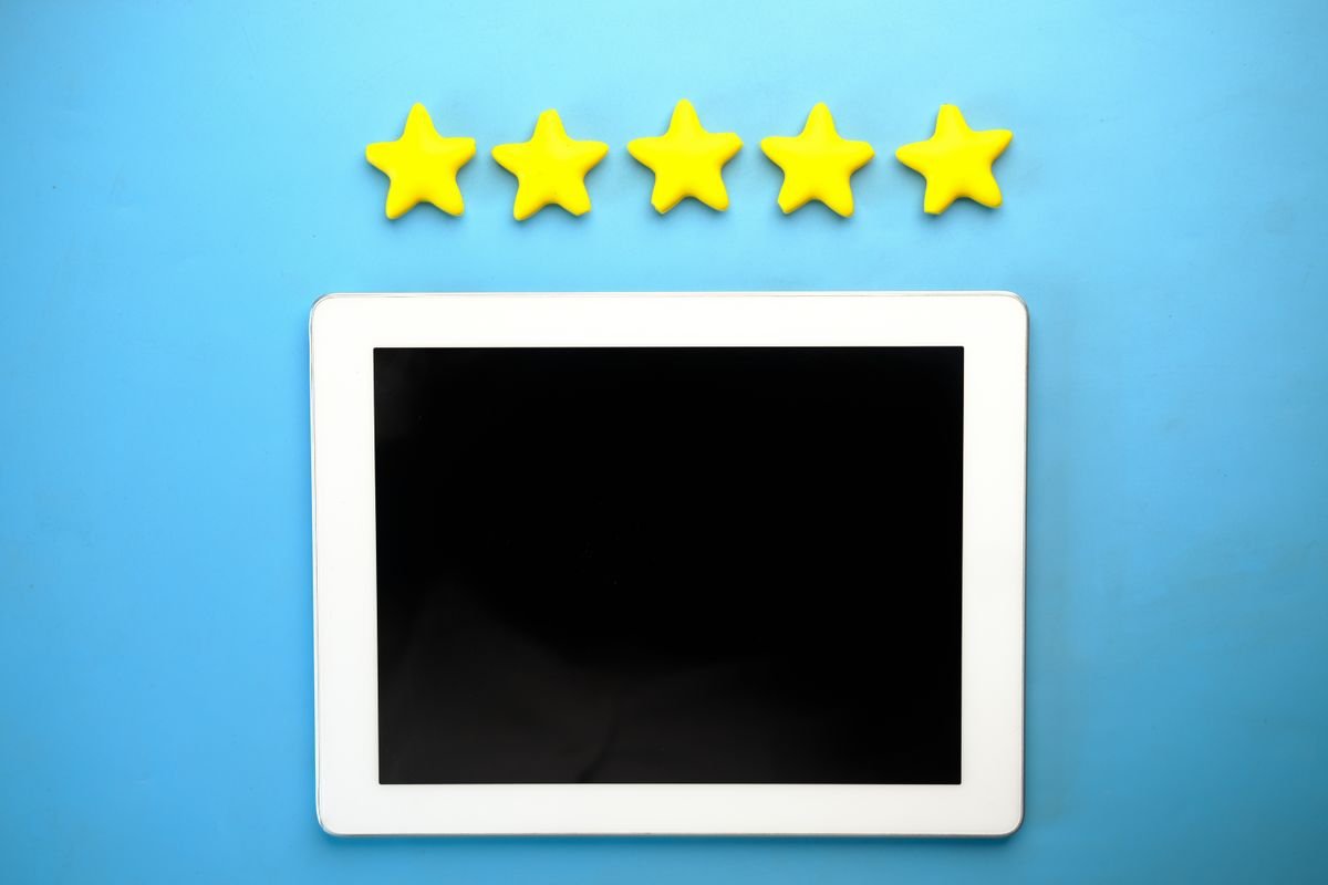 Les avis clients : ce qu’ils valent vraiment Tablette avec cinq étoiles jaunes sur un fond bleu