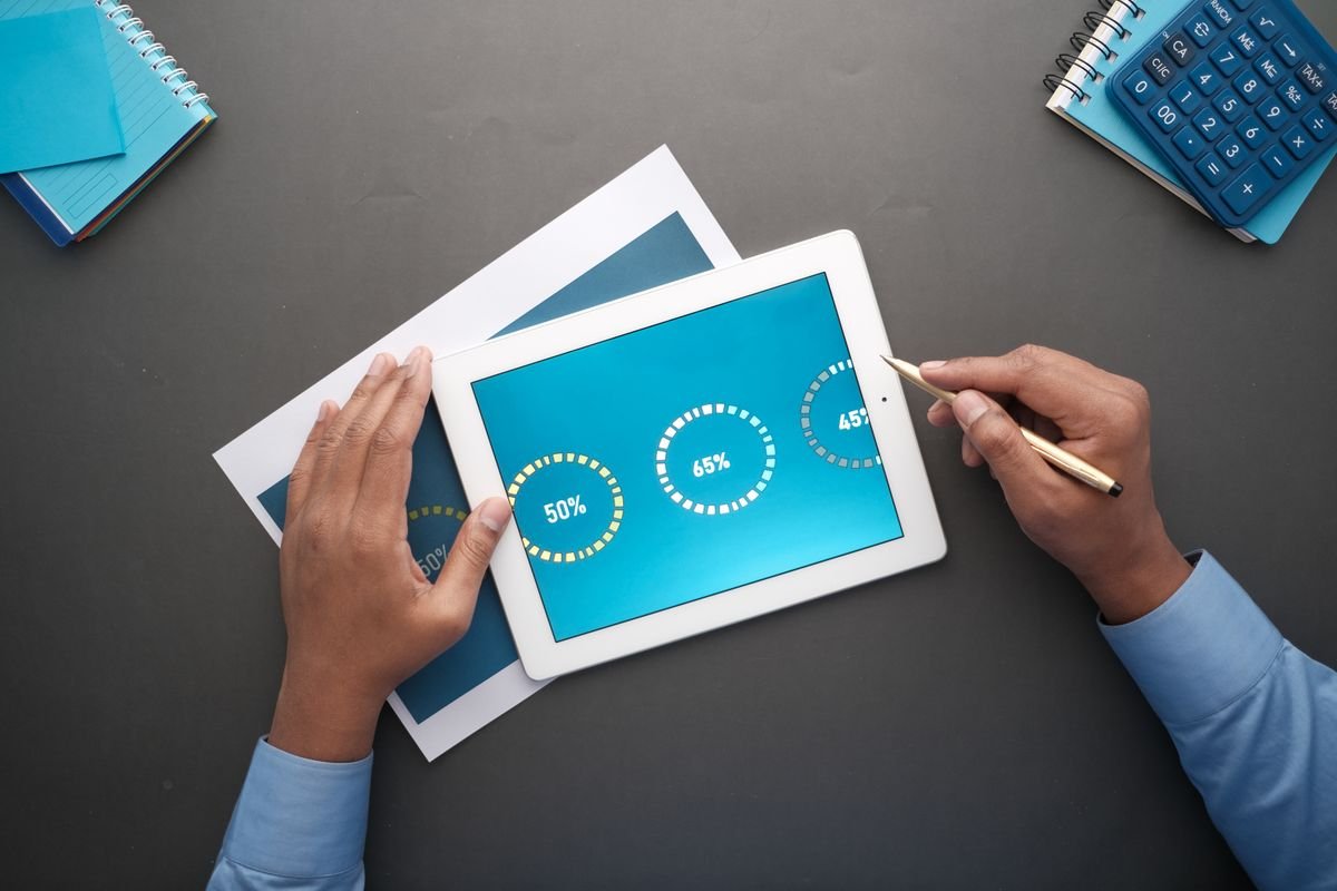 Comprendre la publicité en ligne : le seuil avant de dépenser Un professionnel examinant des données statistiques sur une tablette numérique