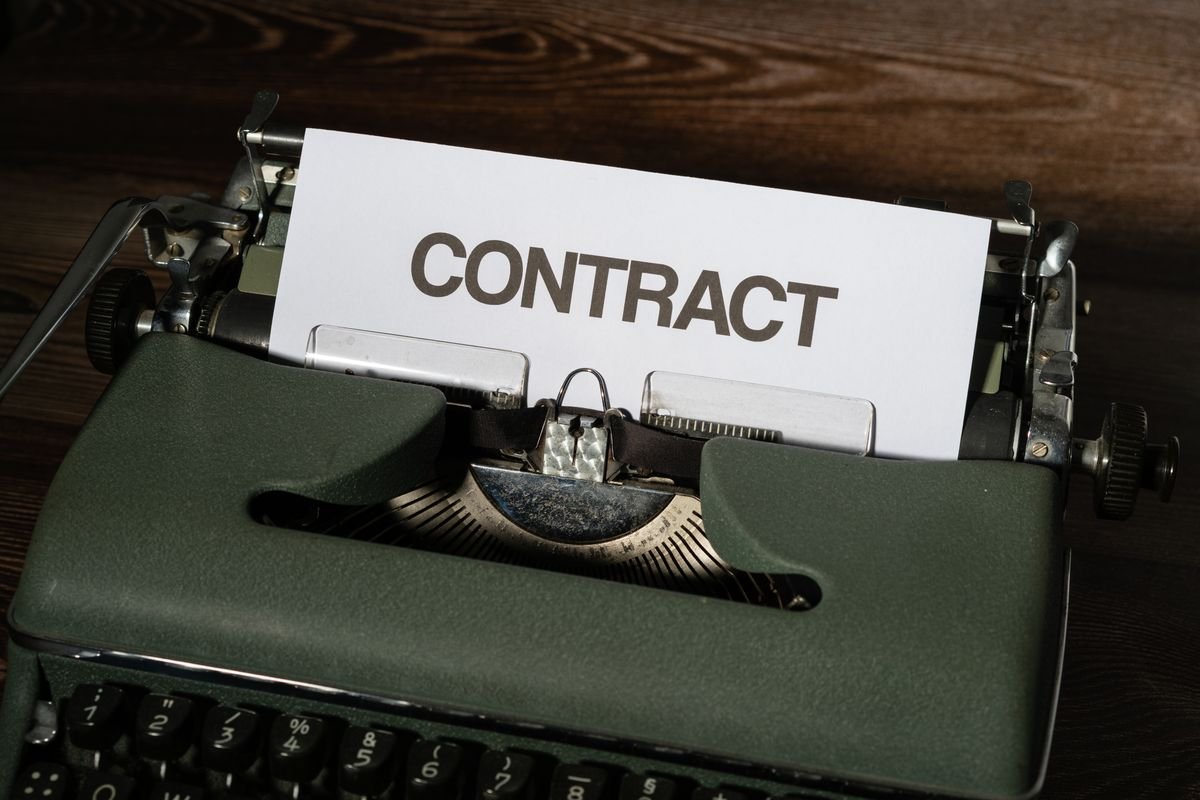 Gros plan sur une machine à écrire vintage avec un papier étiqueté 'Contrat'
