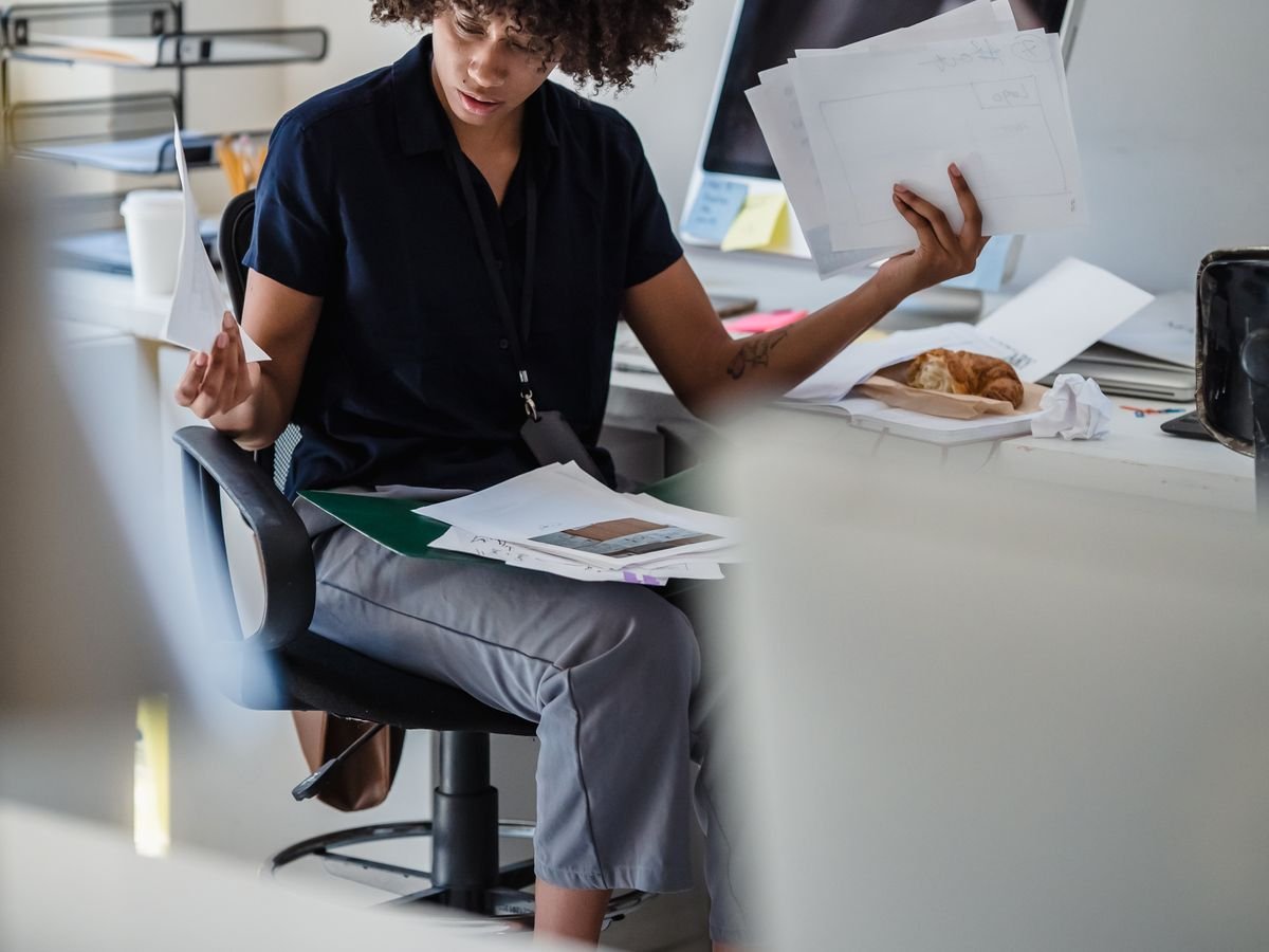 Une personne assise devant une table couverte de papiers administratifs