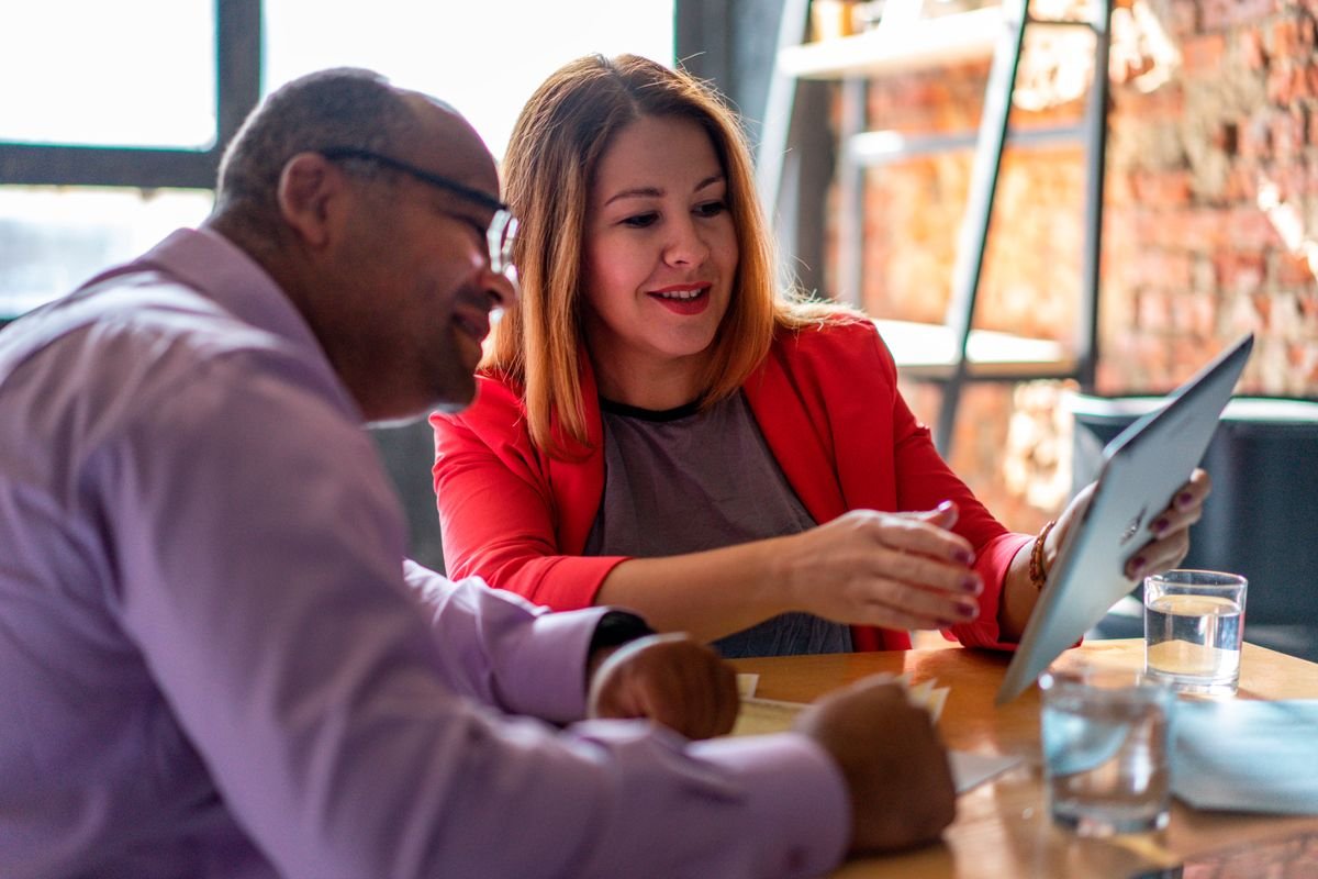 Les avis clients : ce qu’ils valent vraiment Deux adultes engagés dans une conversation productive avec une tablette dans un
