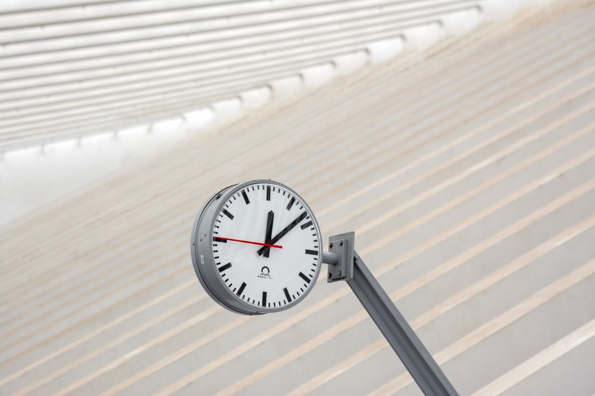 Vue en contre-plongée d'une horloge de gare contre un fond architectural
