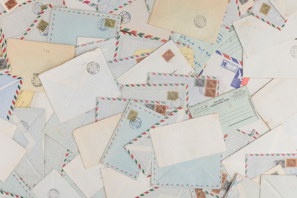 Une collection d'enveloppes et de cartes postales vintage éparpillées avec des