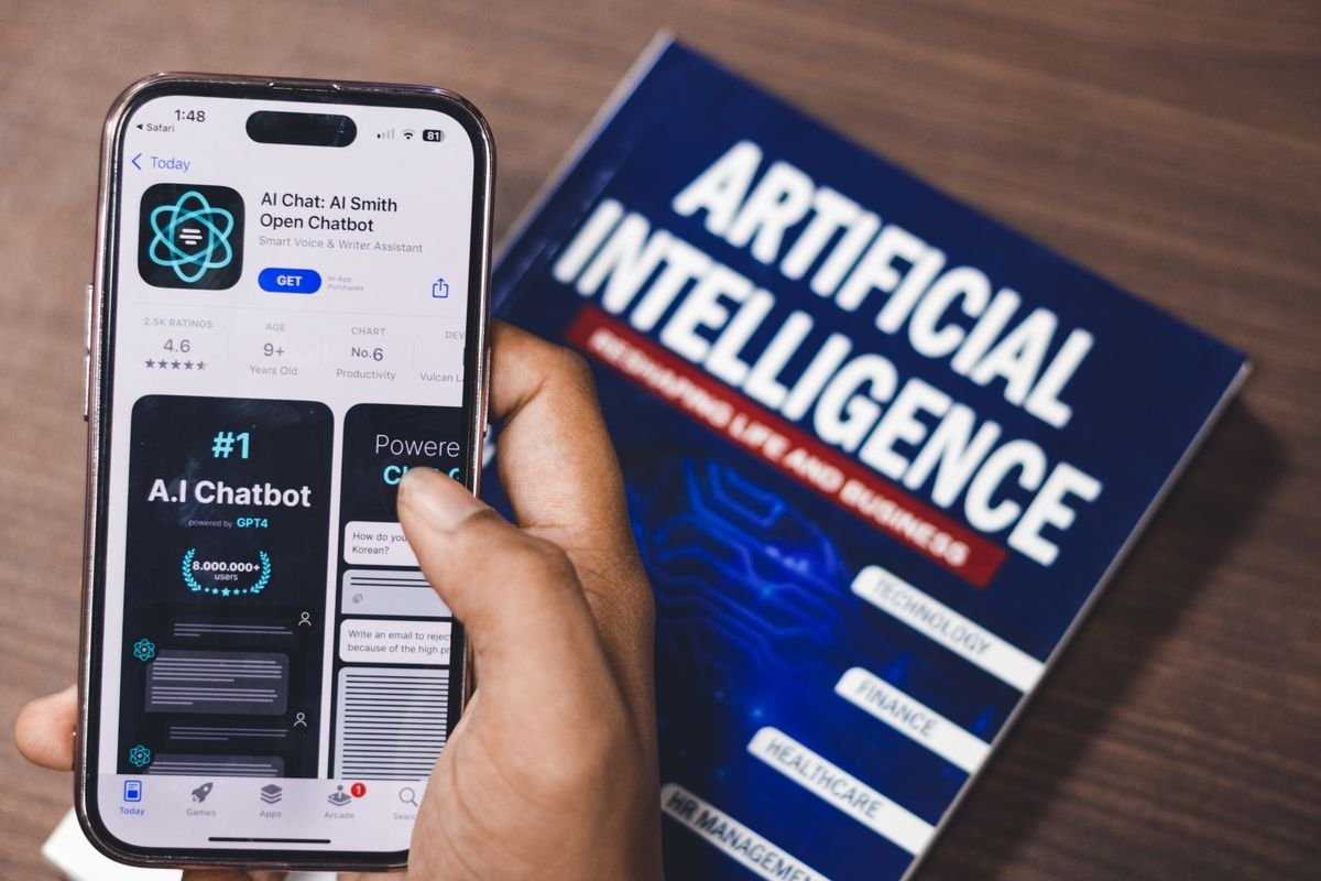 GEO : être cité par ChatGPT, Perplexity et les moteurs de réponse Smartphone affichant une application IA avec un livre sur la technologie IA en