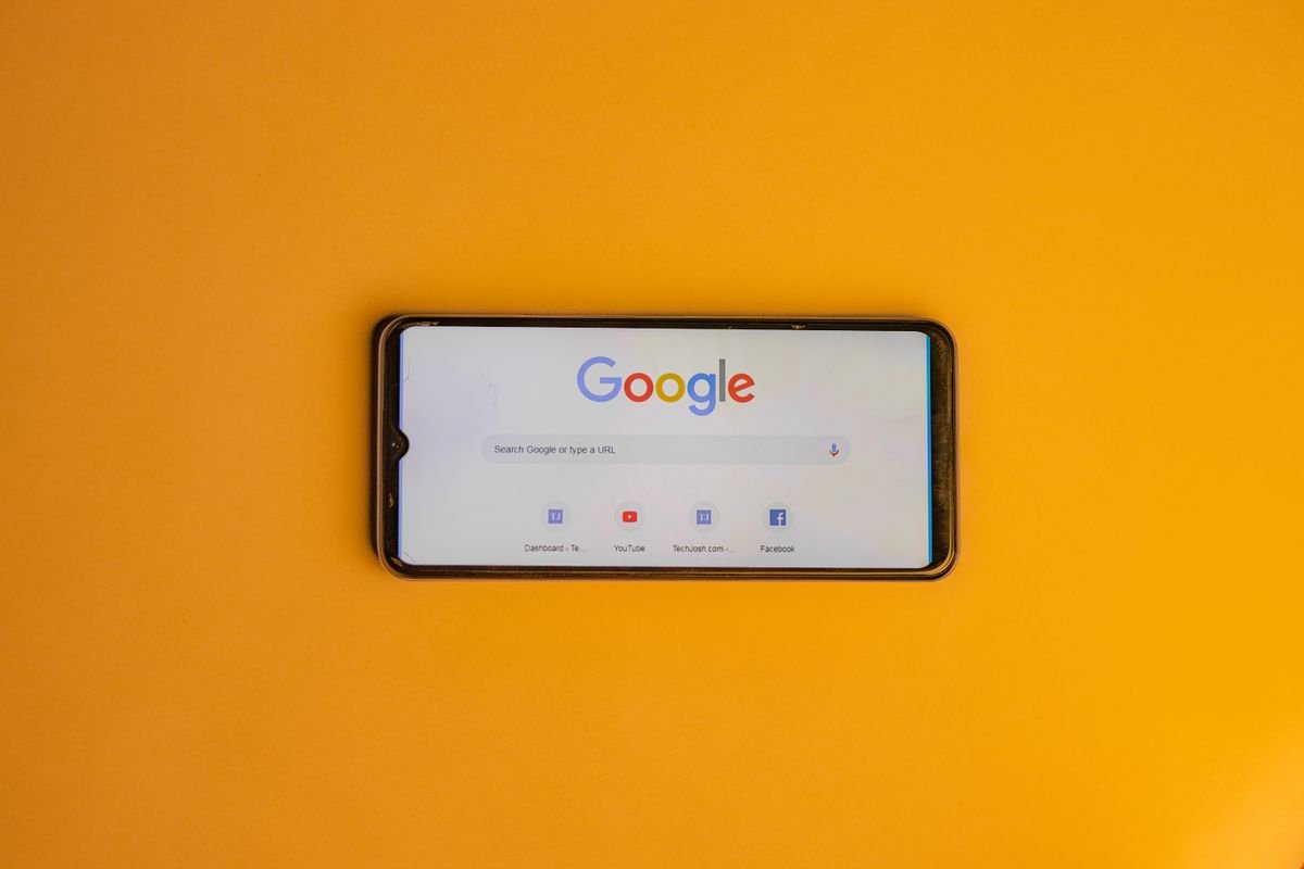 Le référencement d'une boutique en ligne, sans jargon Smartphone affichant la page de recherche Google sur un fond jaune vif