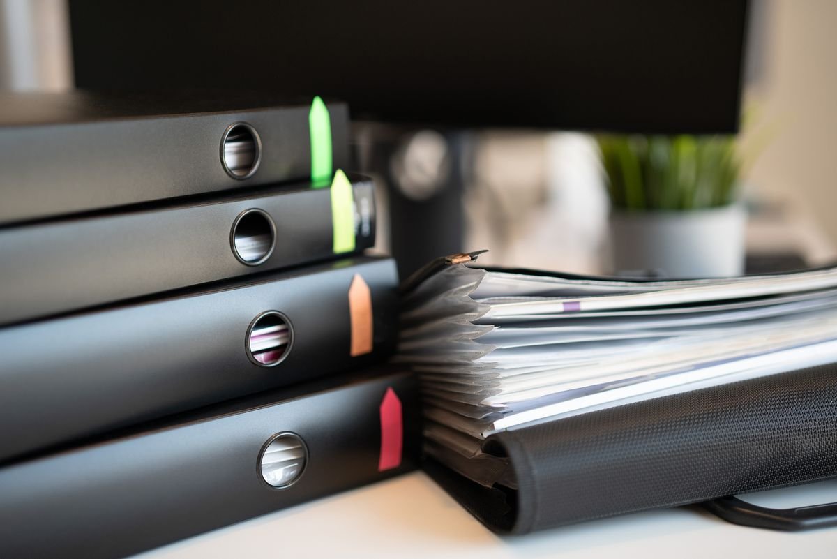 Obligations e-commerce : ce qui a changé depuis 2022 Pile de classeurs colorés et de documents sur un bureau de bureau moderne