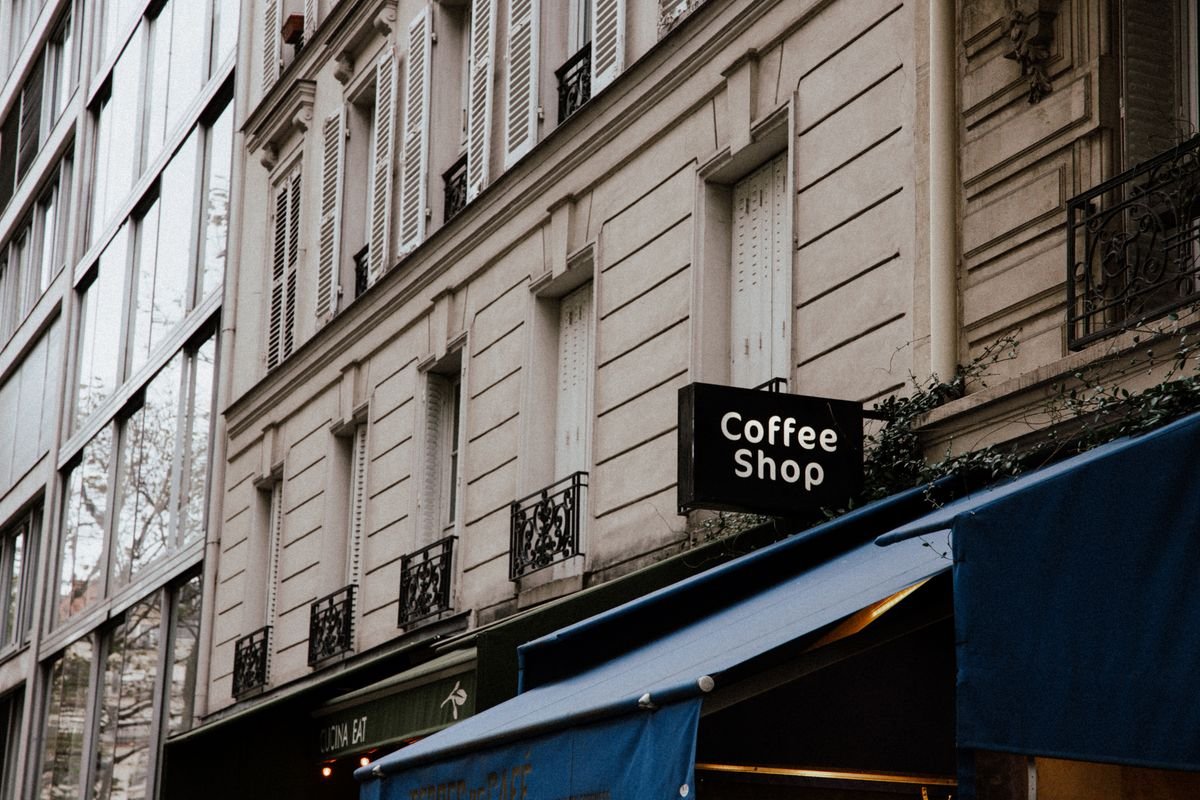 Façade élégante d'une maison de ville avec un panneau de café