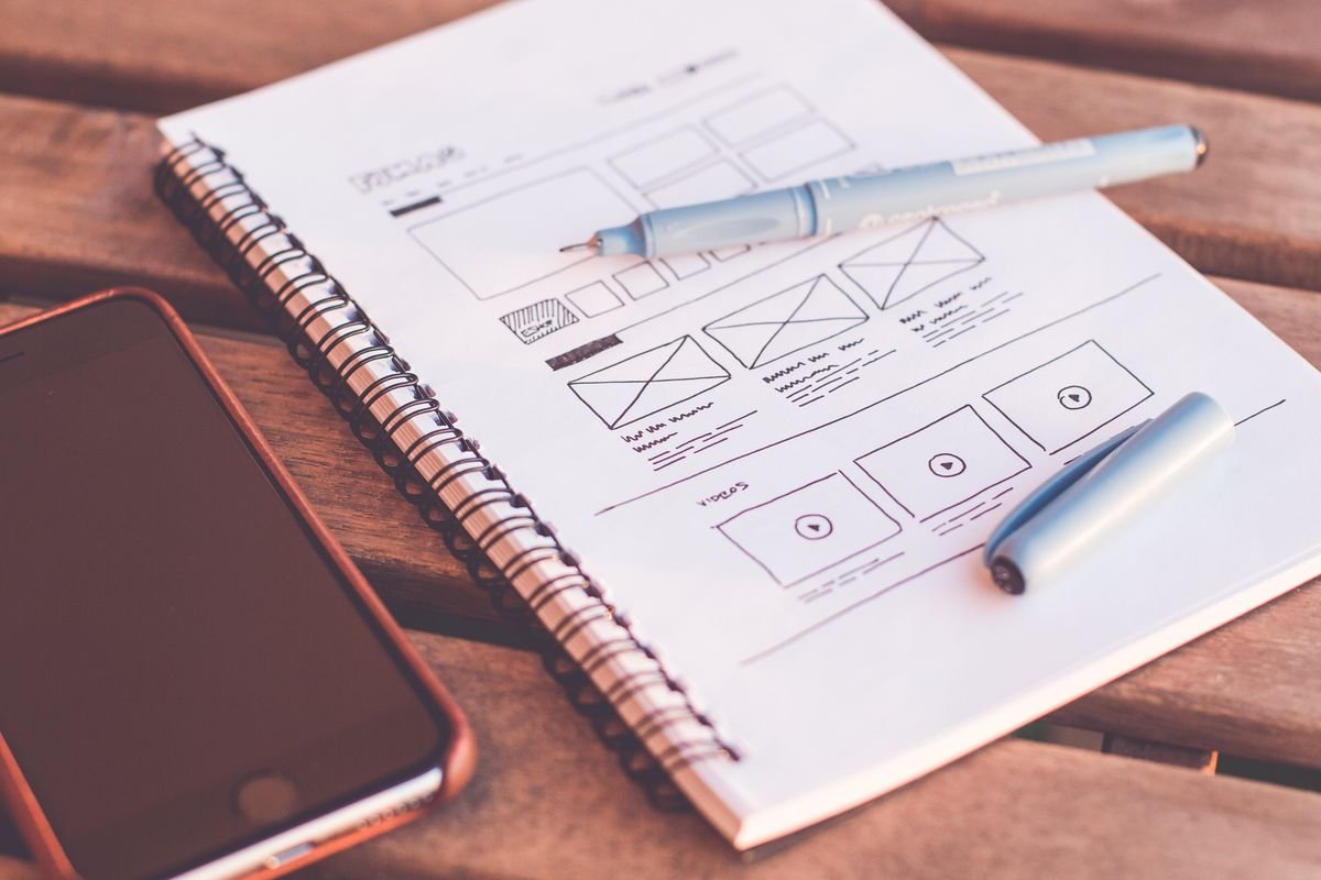 Le référencement d'une boutique en ligne, sans jargon Gros plan d'un carnet avec des croquis filaires et un smartphone sur un bureau