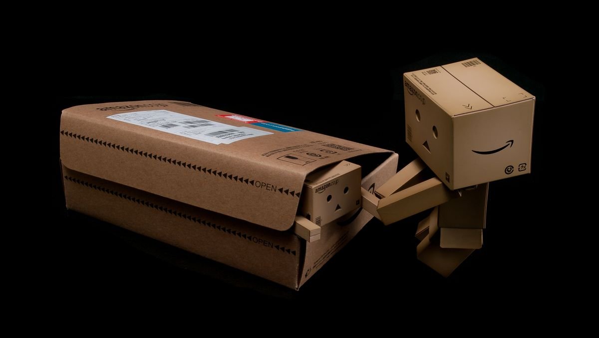 Figure de robot en carton fantaisiste émergeant d'une boîte d'expédition sur