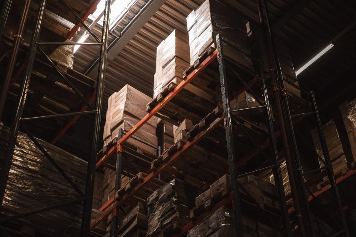 Vue intérieure d'un entrepôt avec des cartons empilés sur des étagères hautes
