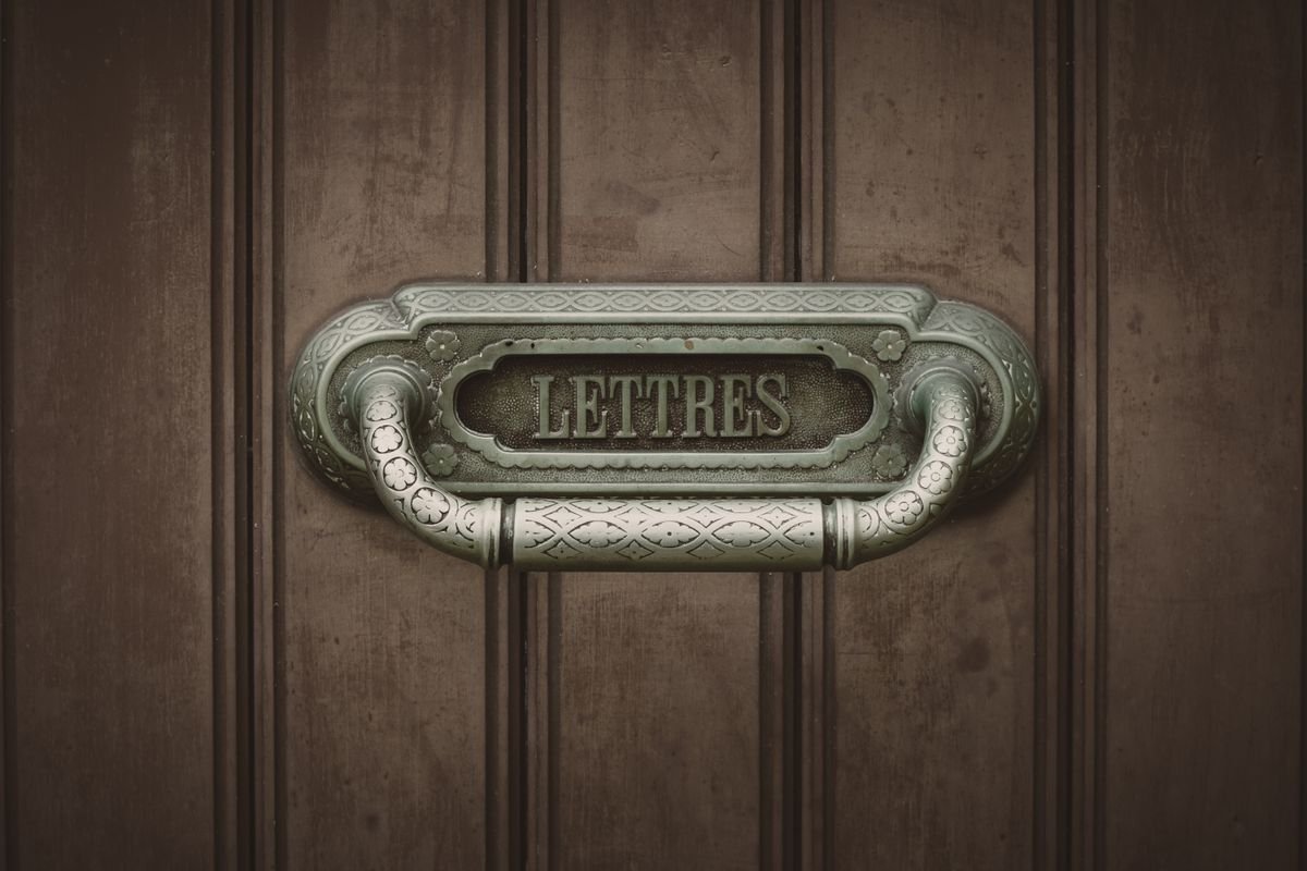 Médiateur de la consommation : l’obligation oubliée Boîte aux lettres vintage ornée, étiquetée 'Lettres', devant une porte en bois