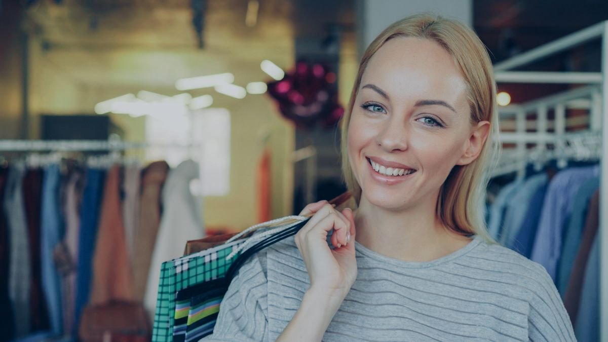 Une femme ravie fait ses achats dans une boutique élégante, tenant des sacs