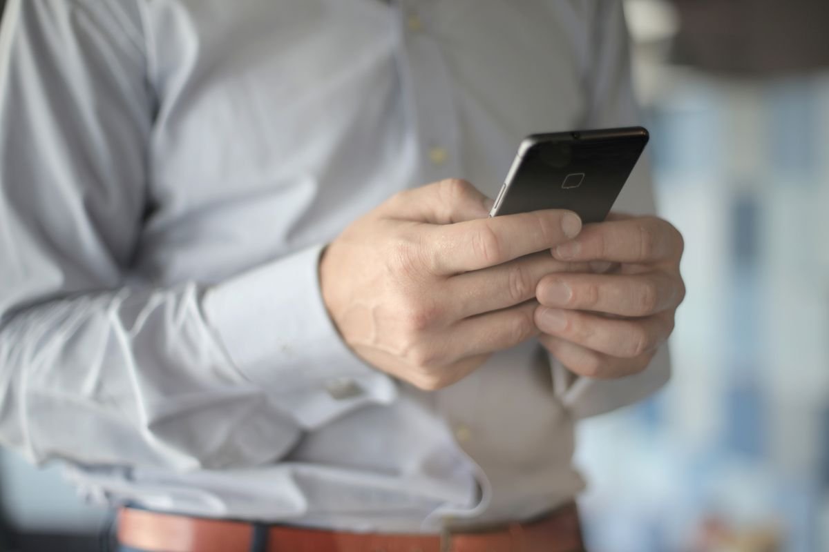Récolter des avis clients : la méthode qui m'en a apporté 2 189 Gros plan sur un homme d'affaires utilisant un smartphone