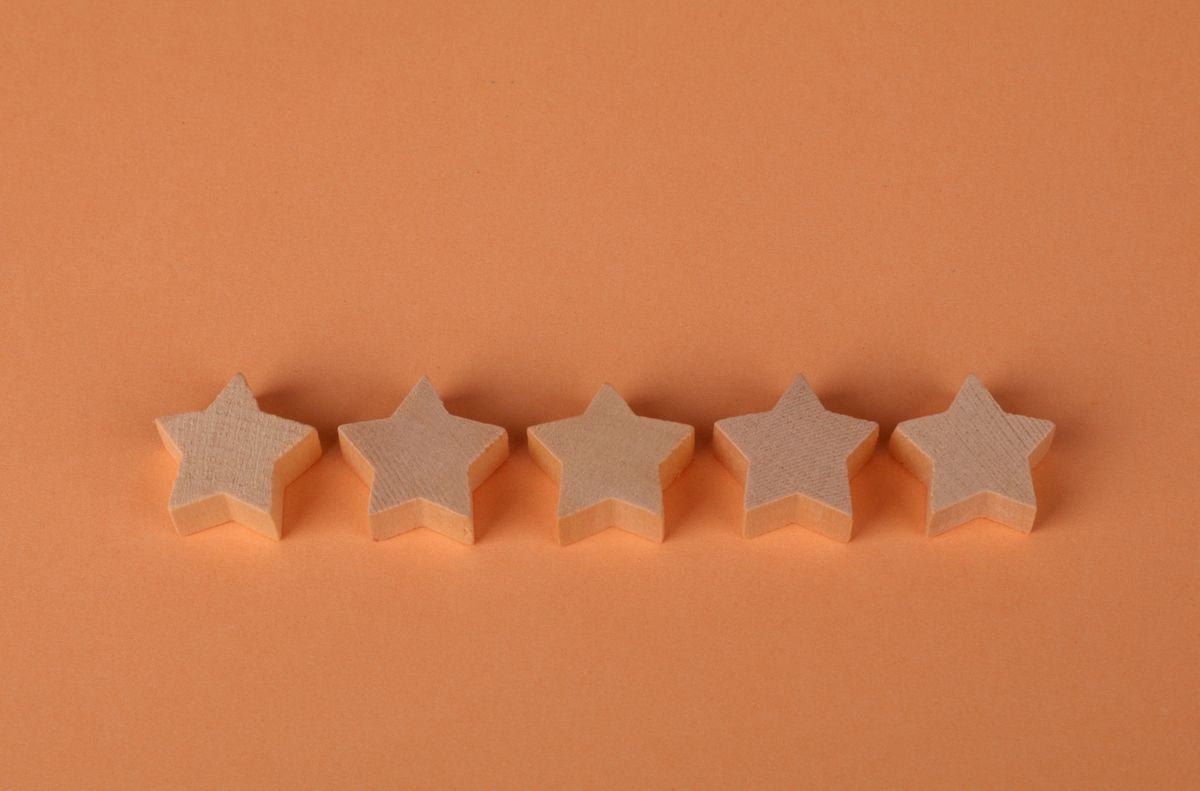 Cinq blocs en bois en forme d'étoile disposés sur une surface orange