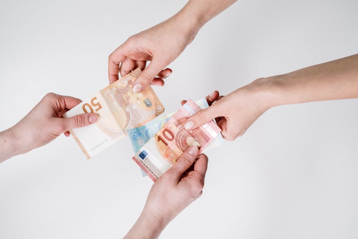 Deux paires de mains échangeant des billets en euros