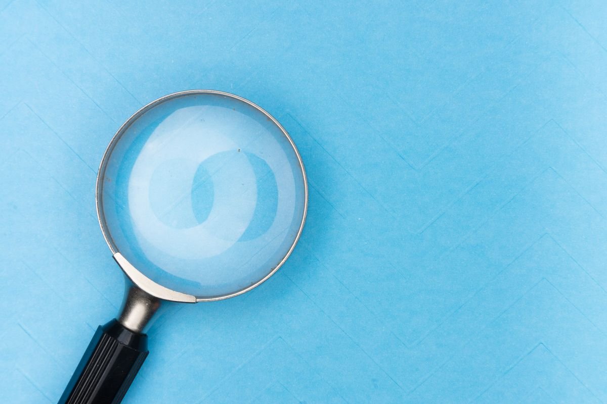 Gros plan d'une loupe sur une surface bleue