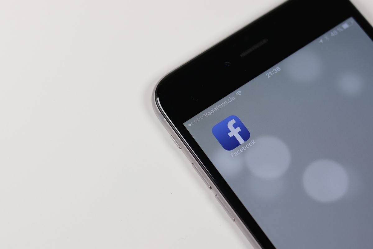 iPhone affichant l'icône de l'application Facebook avec un fond flou
