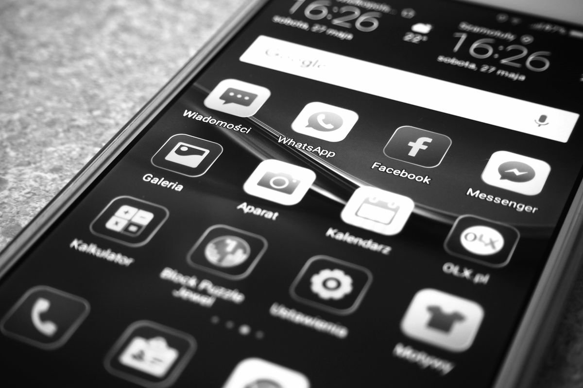 Les avis clients : ce qu’ils valent vraiment Photo en noir et blanc d'un smartphone affichant des icônes d'applications