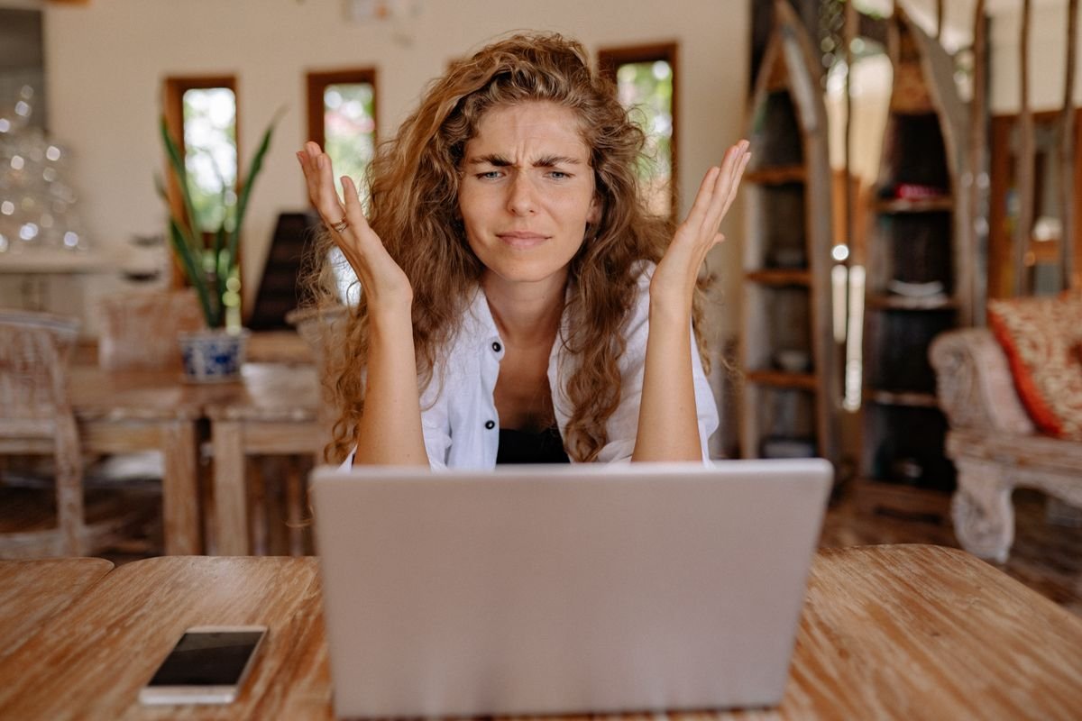 Une femme frustrée avec son ordinateur portable en travaillant à distance à