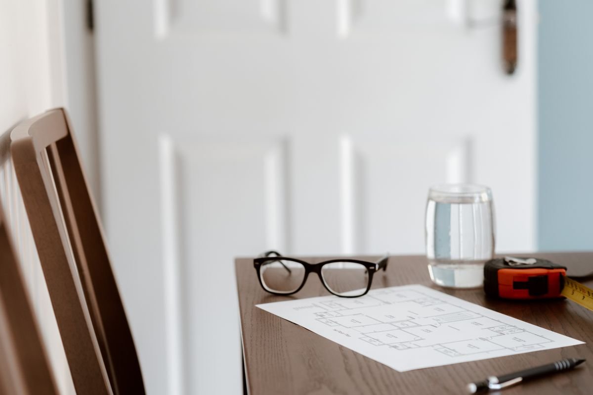 Un bureau à domicile contemporain avec des plans, des lunettes et un mètre