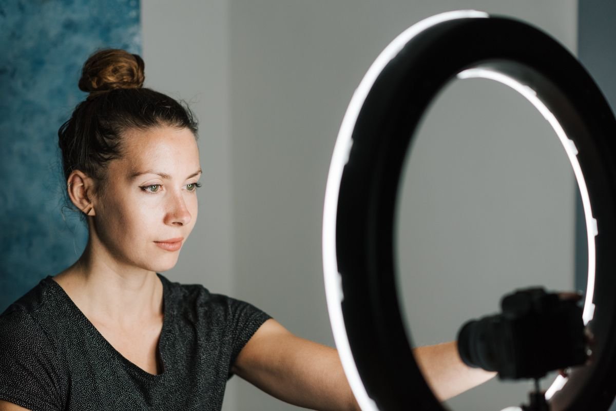 Une jeune femme utilisant une lumière en anneau dans un environnement de studio