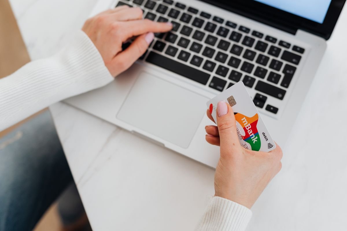 Gros plan sur une personne utilisant un ordinateur portable et tenant une carte