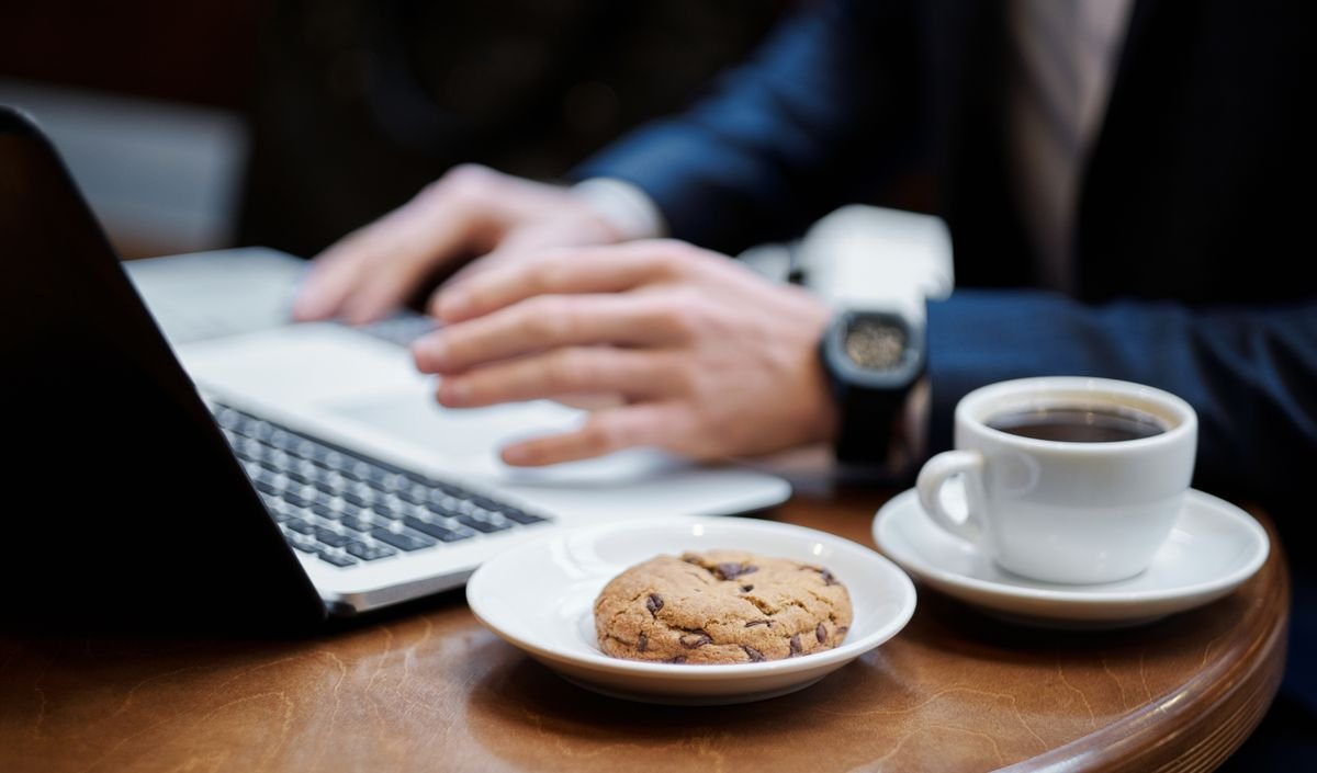 Obligations e-commerce : ce qui a changé depuis 2022 Un professionnel travaillant sur un ordinateur portable avec un café et un