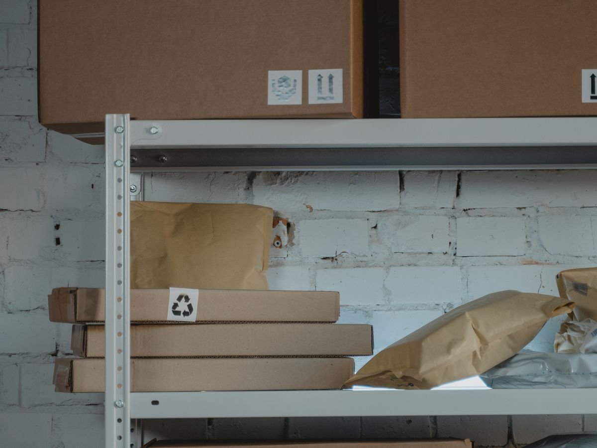 Vendre sur Amazon : les deux choix à faire, et ce qu’ils coûtent Quelques colis posés sur une étagère dans un petit local