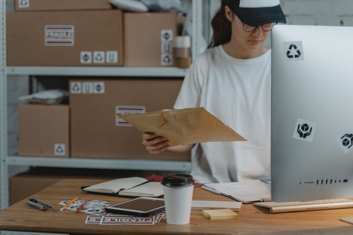 Femme triant des colis à son bureau dans un bureau de logistique